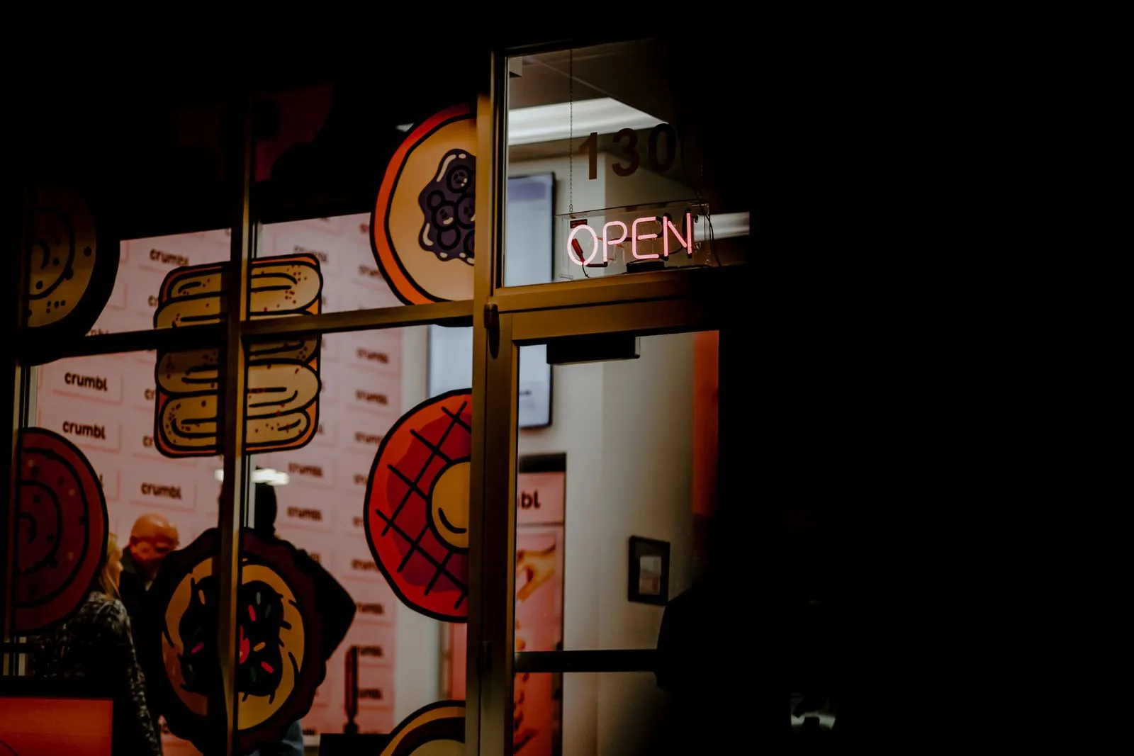Night view of a cookie shop with neon sign in Colorado Springs.